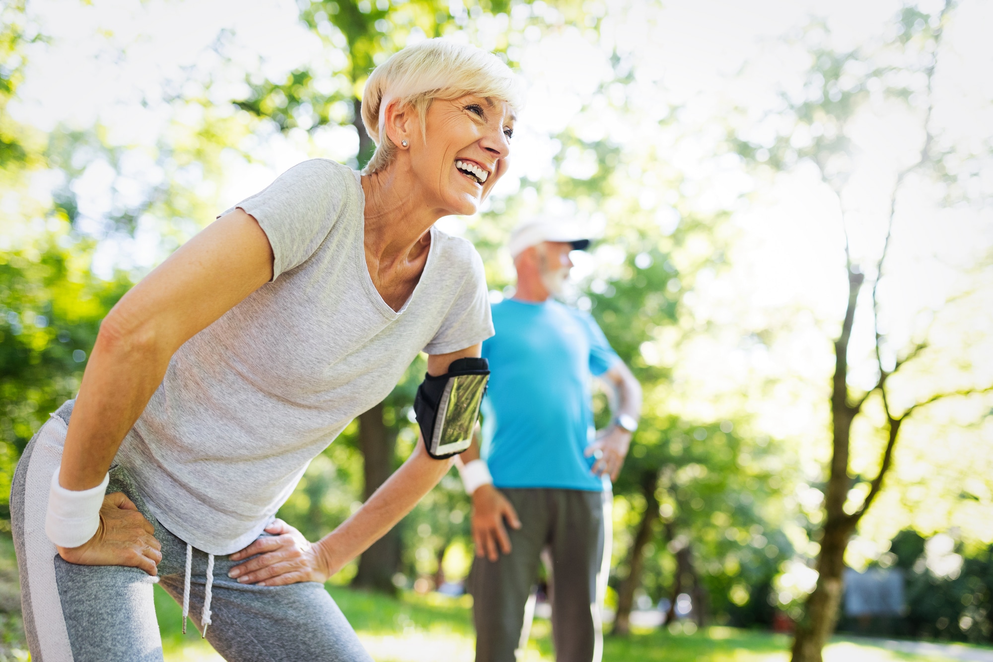 Happy mature couple stretching during running in the park Happy senior couple stretching during jogging in the park